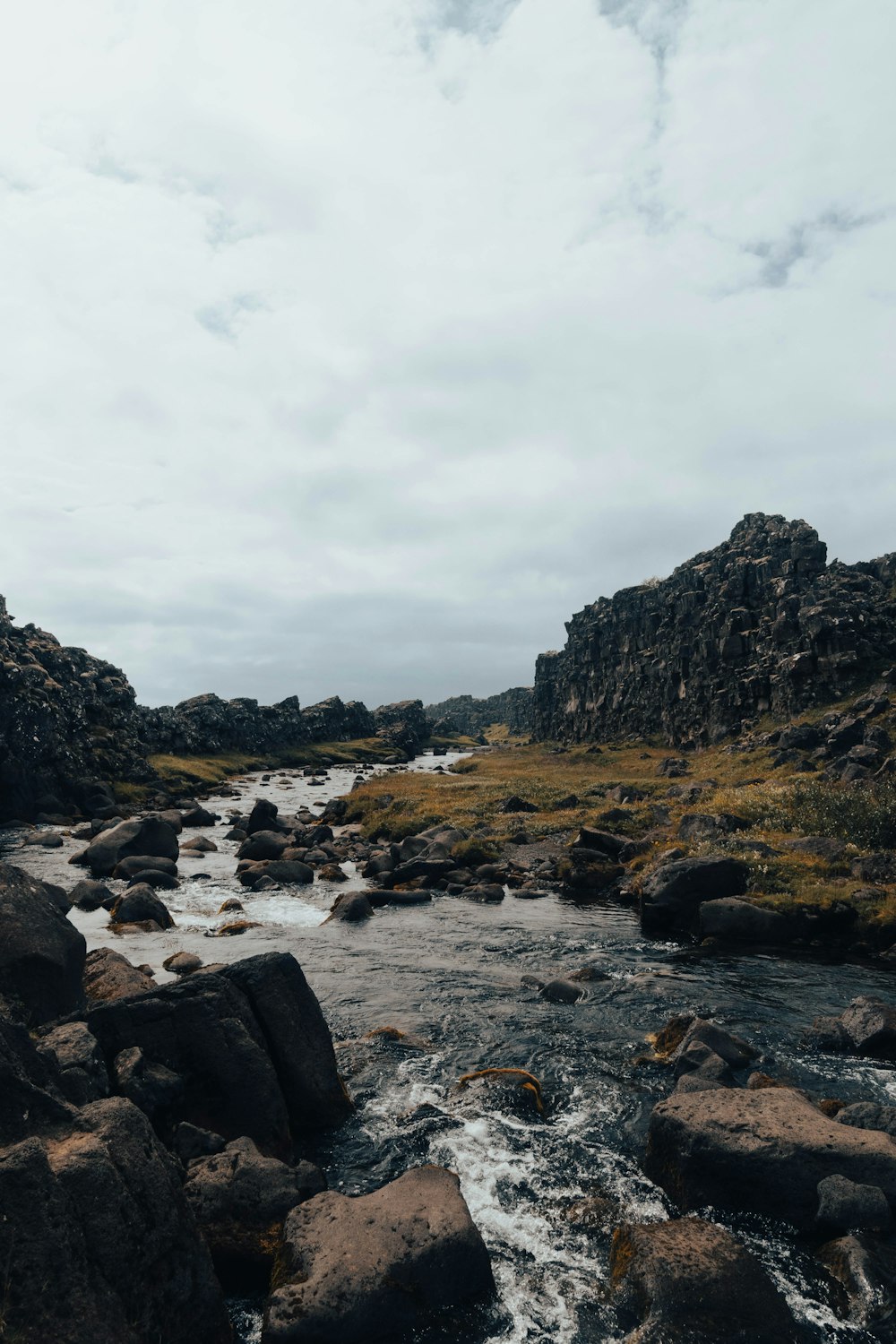 a river running through a lush green rocky hillside