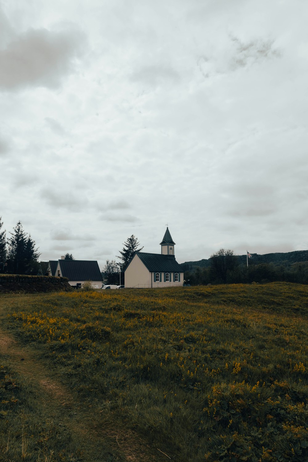 a white house in a field with trees in the background