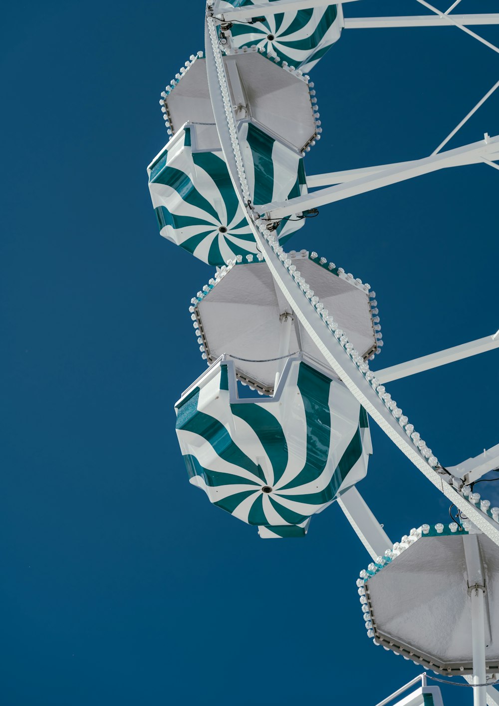 a green and white ferris wheel against a blue sky