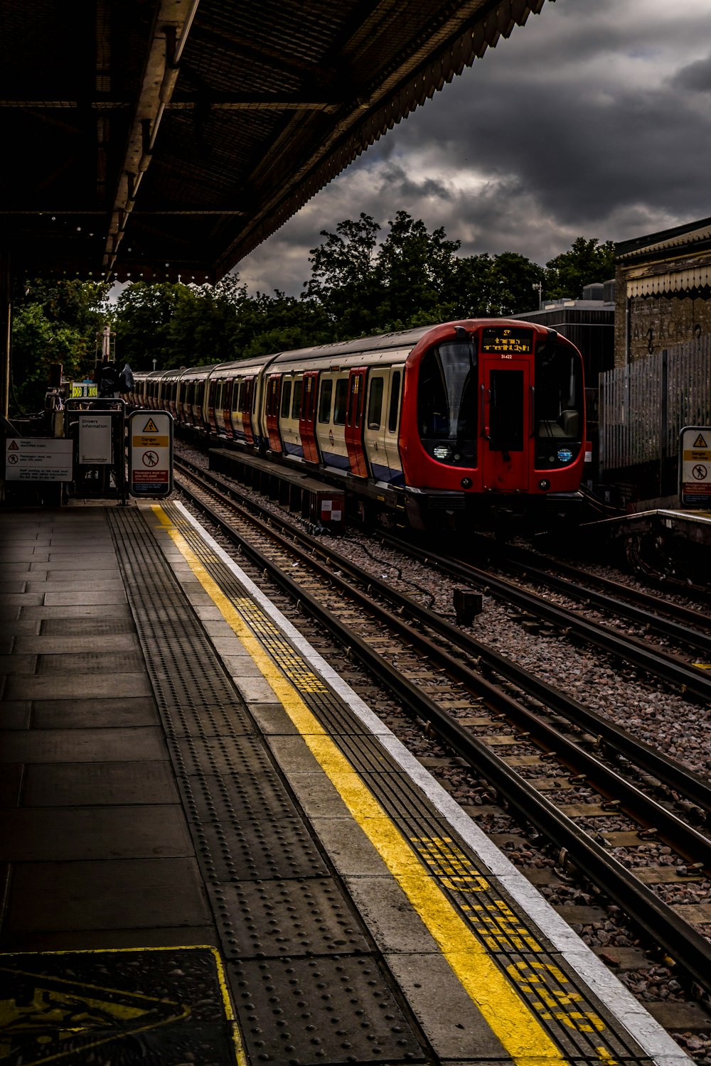 a red and white train pulling into a train station