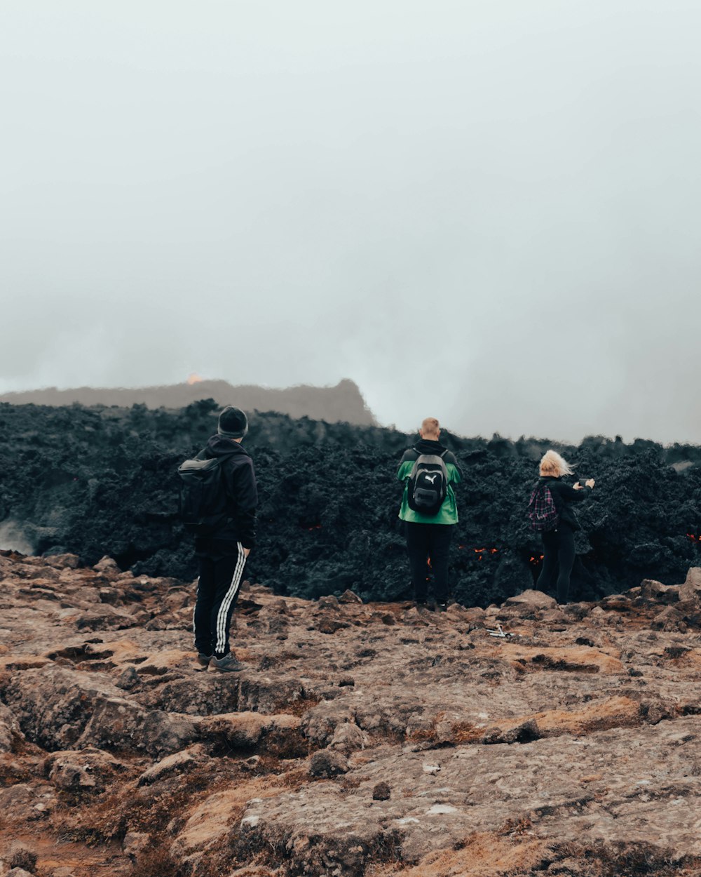 a group of people standing on top of a rocky hill