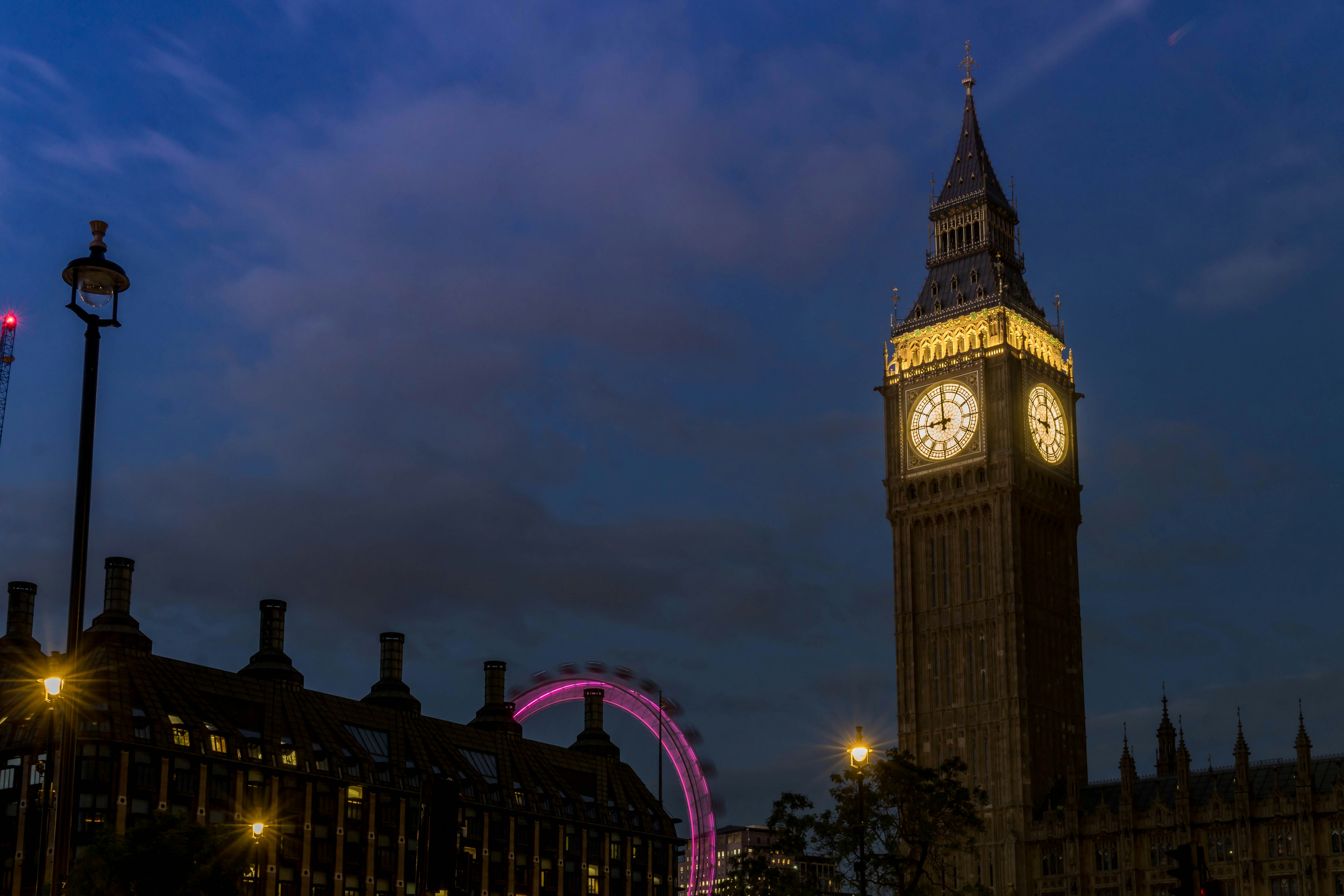 A large clock tower towering over a city at night photo – Free London ...