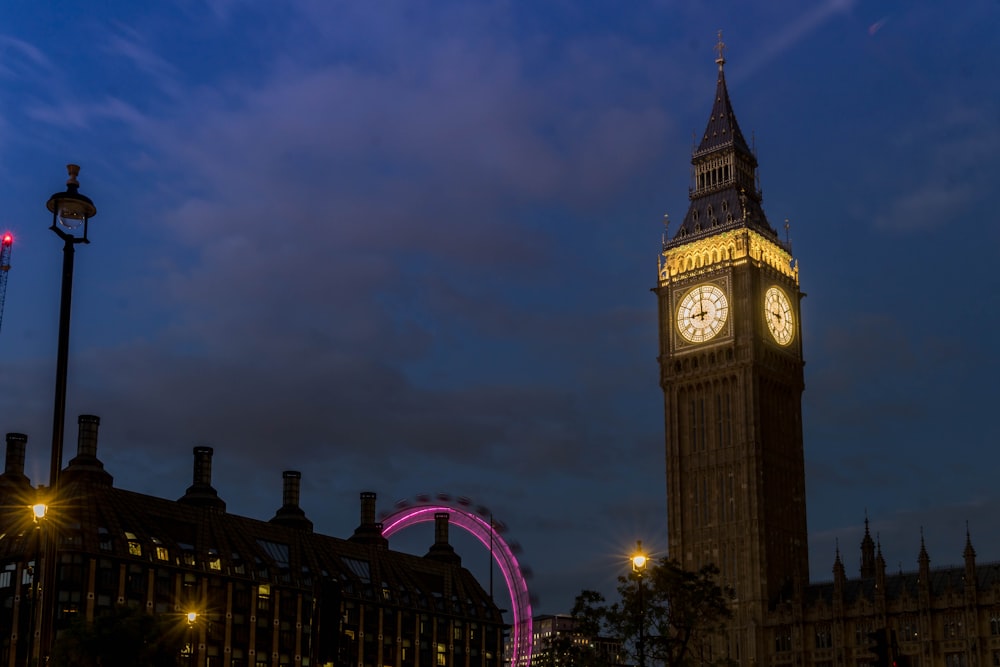 a large clock tower towering over a city at night