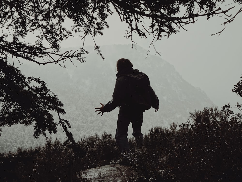 a person with a backpack standing on a hill