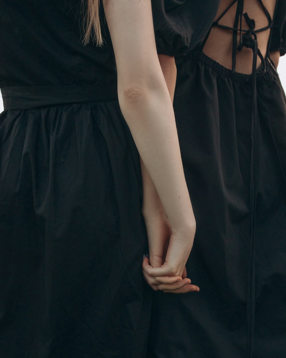 two women standing next to each other holding hands