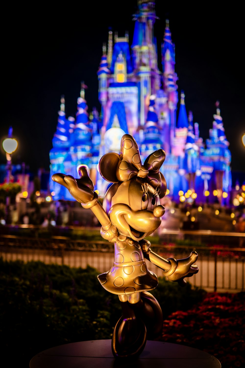 a statue of mickey mouse in front of a castle