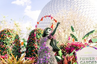 a statue of a woman in a flower garden