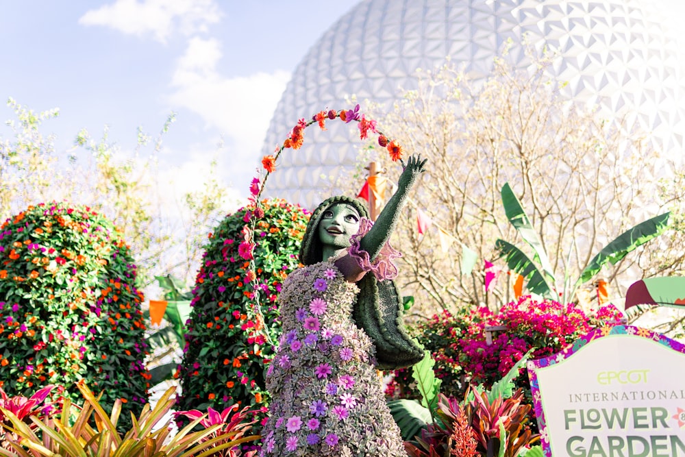 a statue of a woman in a flower garden