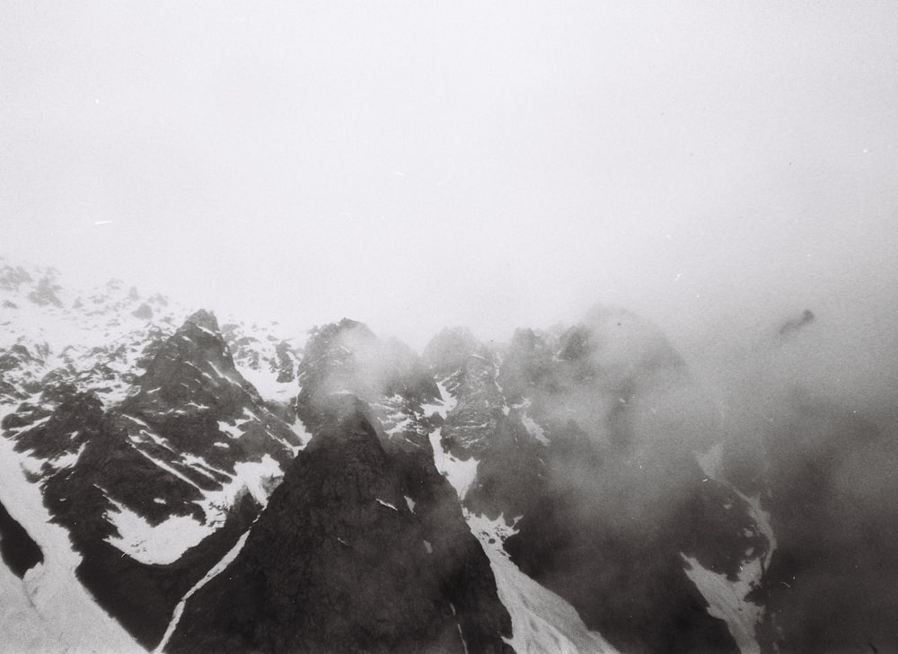 a black and white photo of snow covered mountains