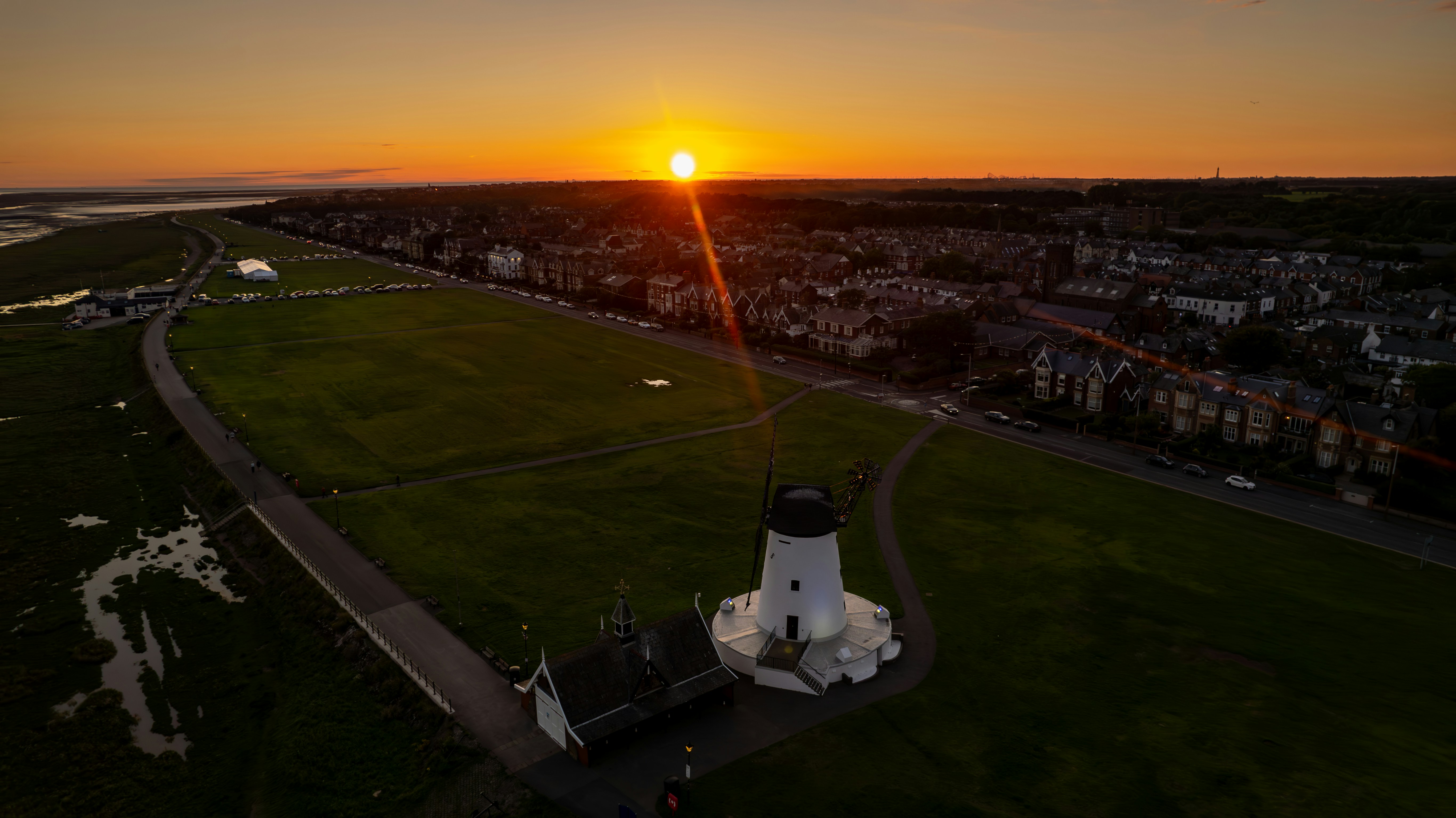 An aerial view of a lighthouse at sunset