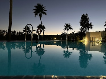 A quiet evening at a local Durgapur swimming pool, lights shimmering on the water surface.