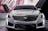 A sleek and modern car with a prominent front grille, angular headlights, and a smooth hood design. The car is set against a sophisticated backdrop that features geometric shapes and lines.