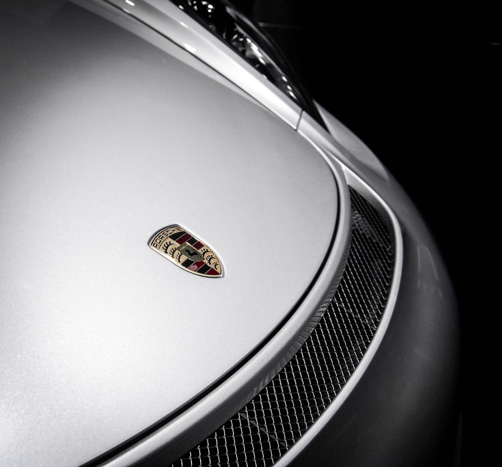 the emblem on the front of a silver sports car