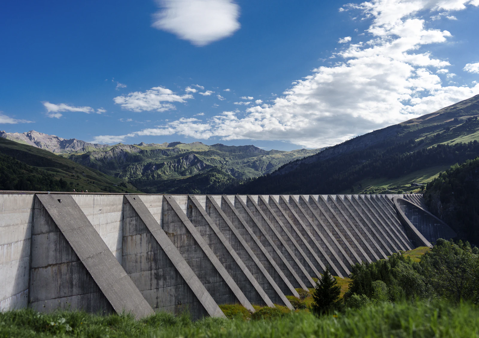 Barrage voûte en béton devant des montagnes (barrage de Roselend, image d'illustration)