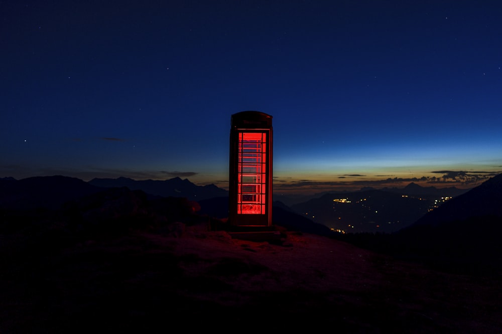 un'alta torre rossa seduta sulla cima di una montagna