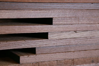 Close-up of smooth wooden planks stacked neatly in a workshop.