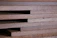 Close-up of finely cut wooden planks stacked neatly in a workshop.