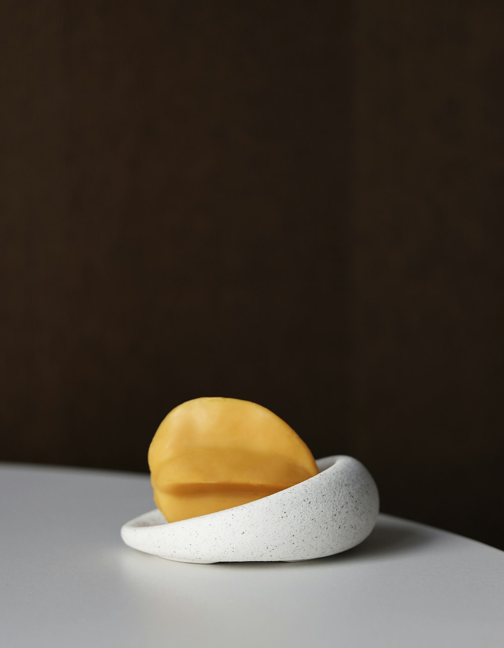 a piece of fruit sitting on top of a white table