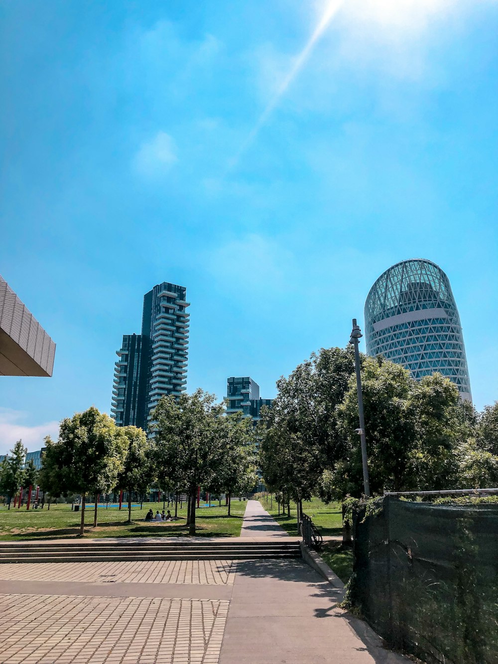 a view of a park with trees and buildings in the background