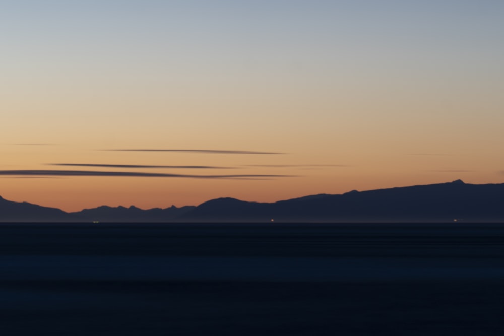 a plane flying over a mountain range at sunset