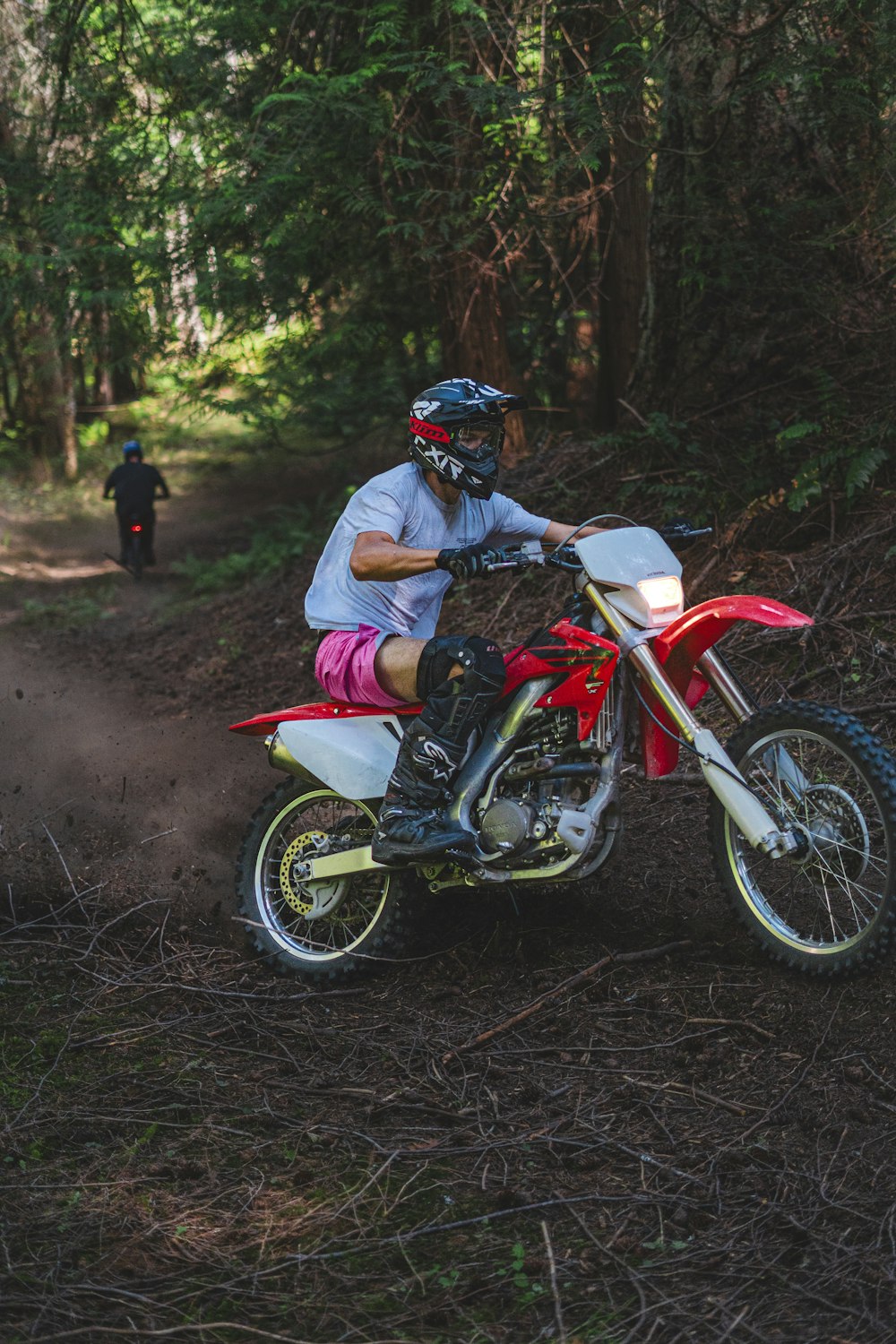 a man riding on the back of a red dirt bike