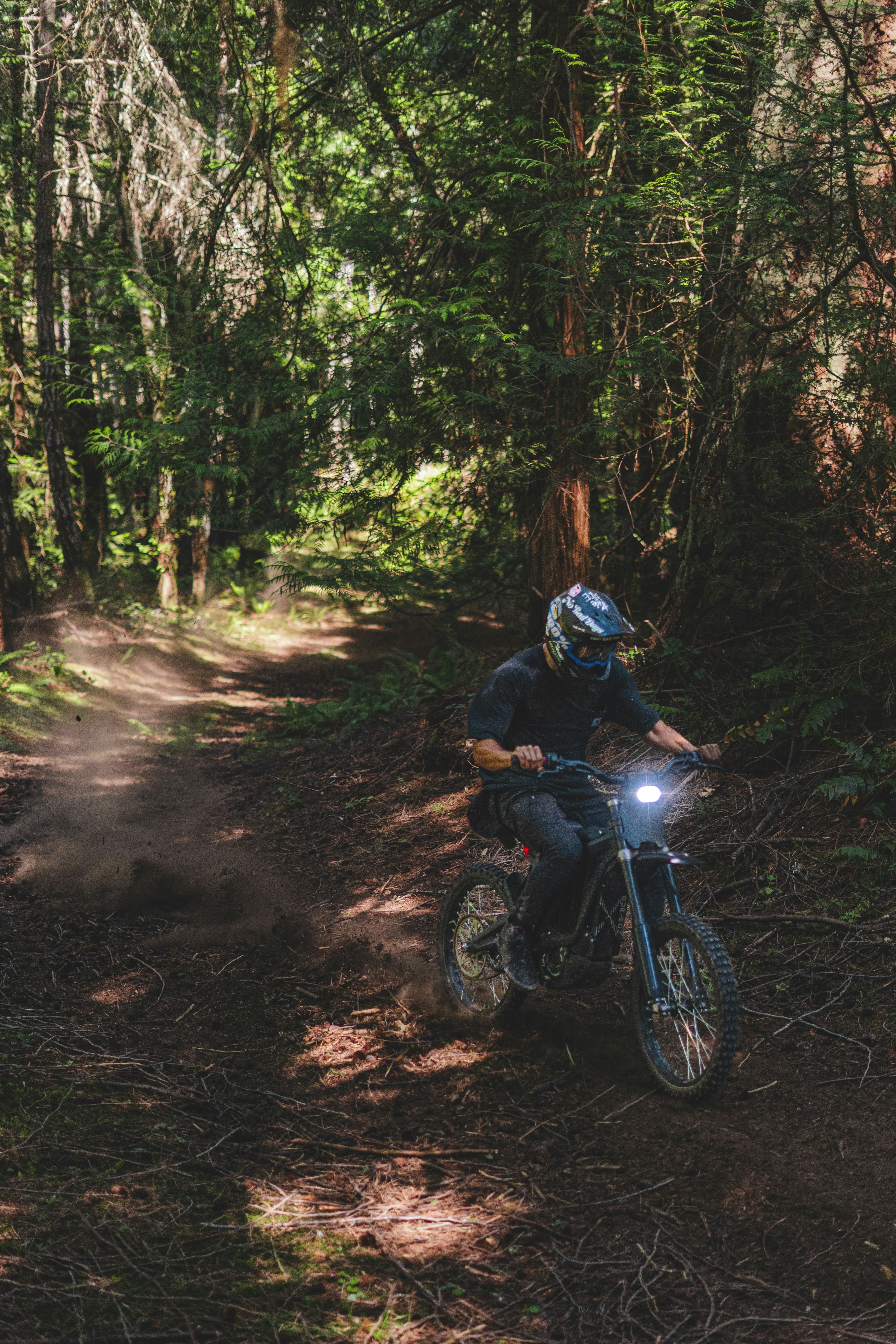 a man riding a motorcycle down a dirt road