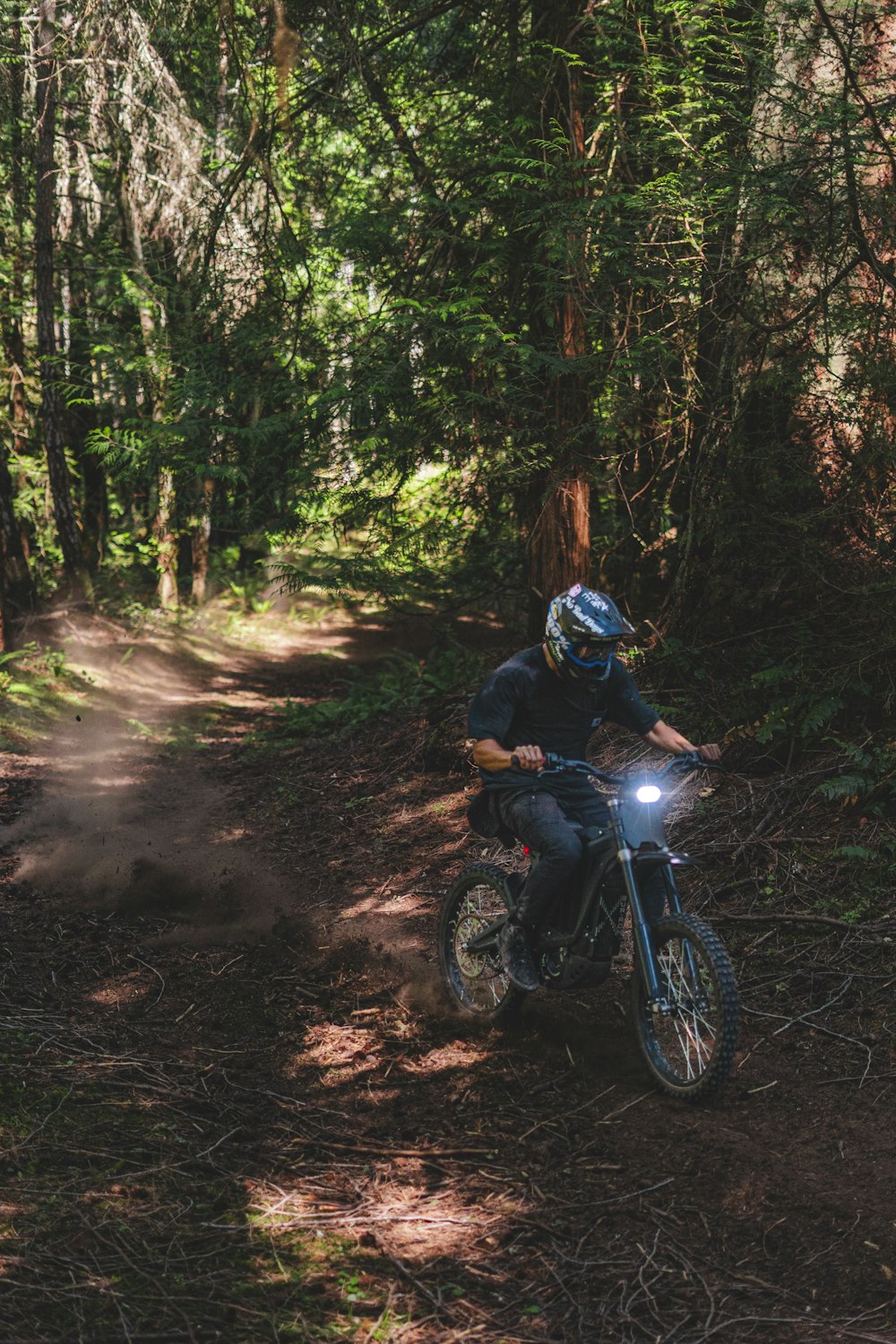 a man riding a motorcycle down a dirt road