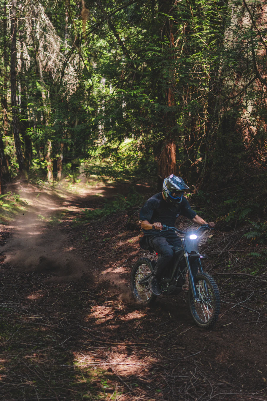Rider on an electric dirt bike carving a forest trail