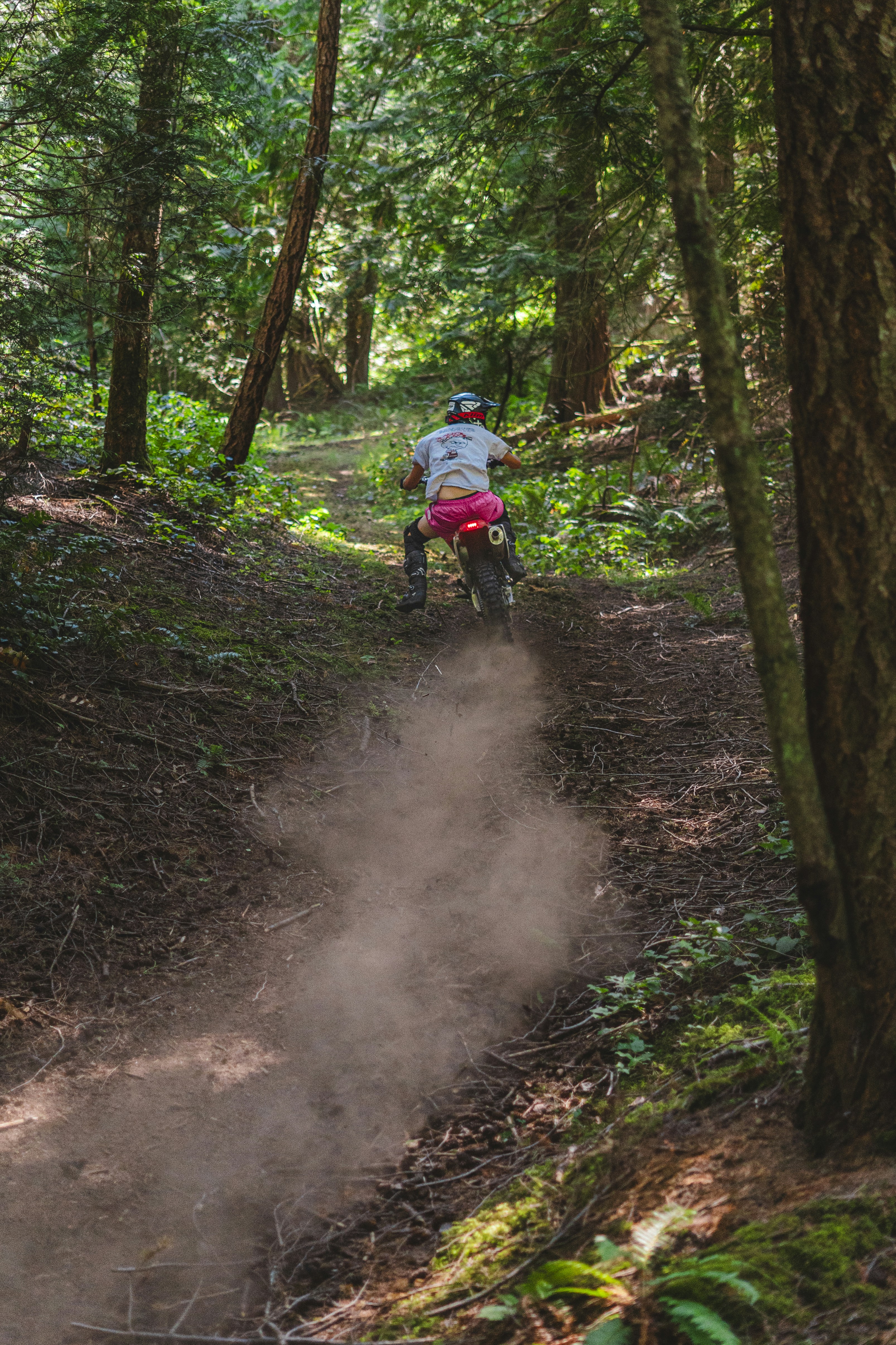 a person riding a dirt bike on a trail in the woods