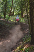 Close-up of a powerful Honda dirt bike kicking up mud on a forest trail