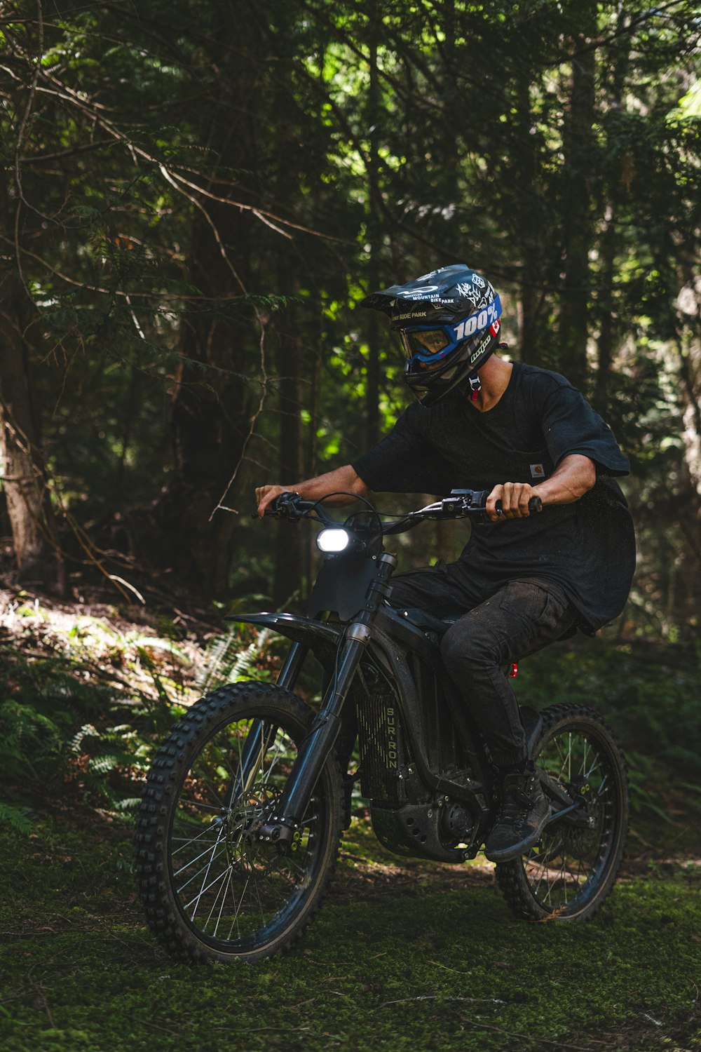 a man riding a dirt bike through a forest