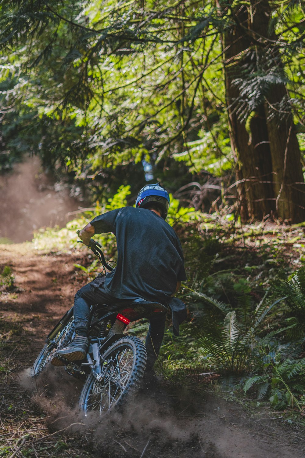 a man riding a dirt bike through a forest