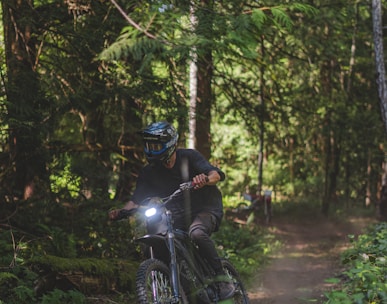 a man riding a dirt bike through a forest