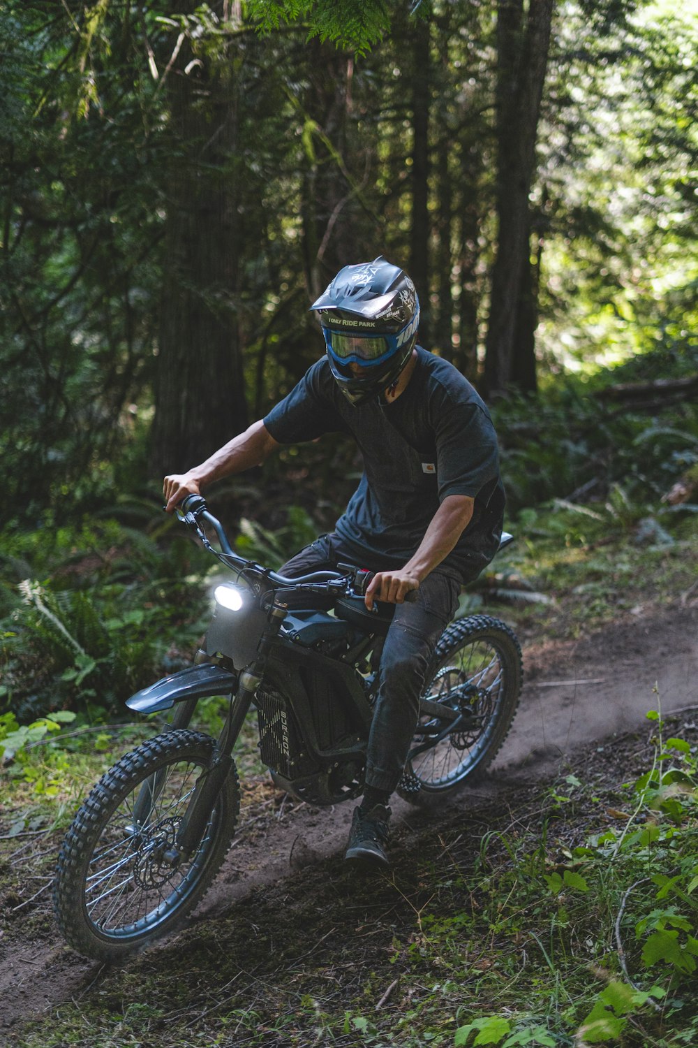 a man riding a dirt bike through a forest