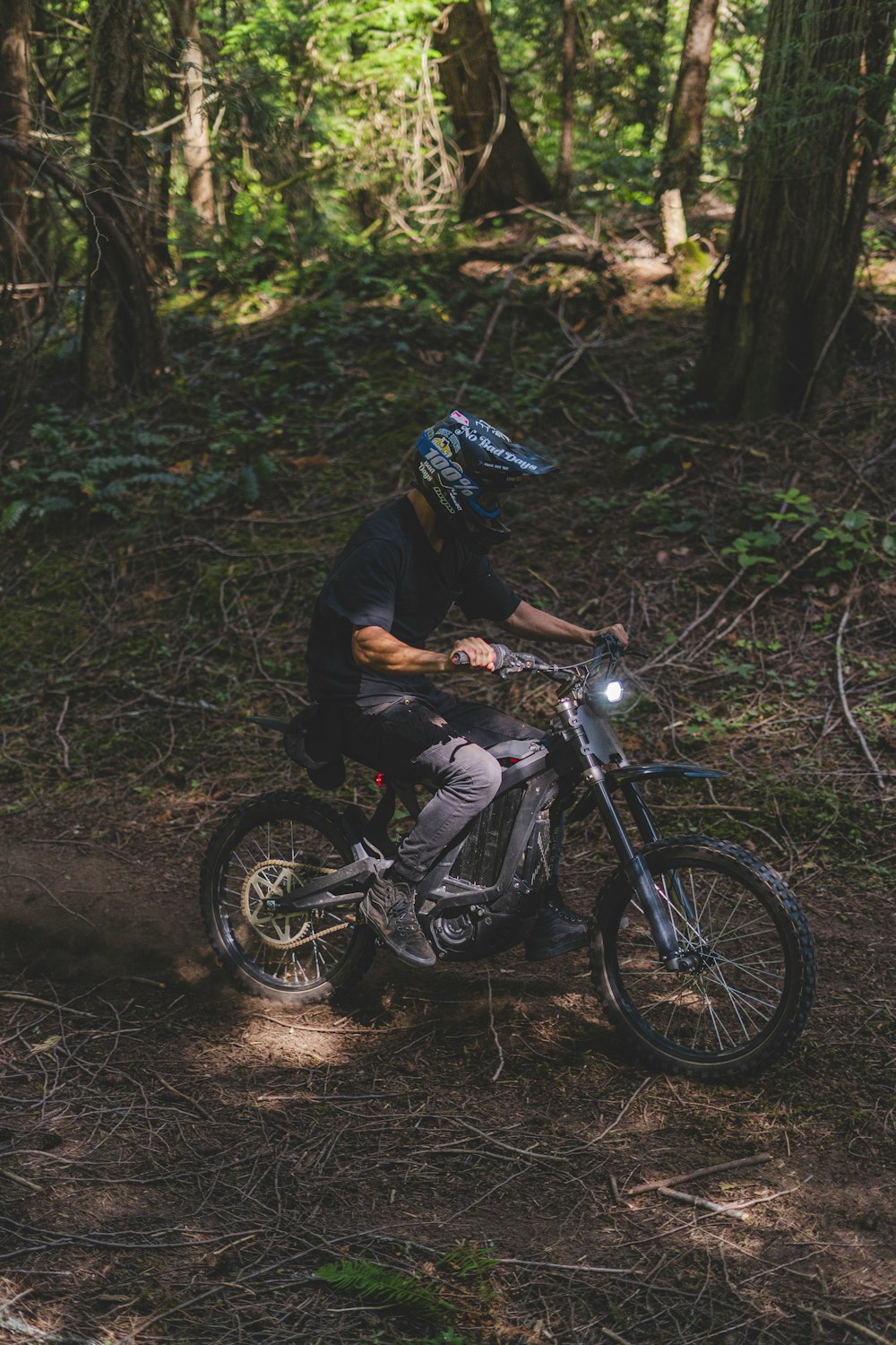 Un uomo in sella a una moto da cross attraverso una foresta