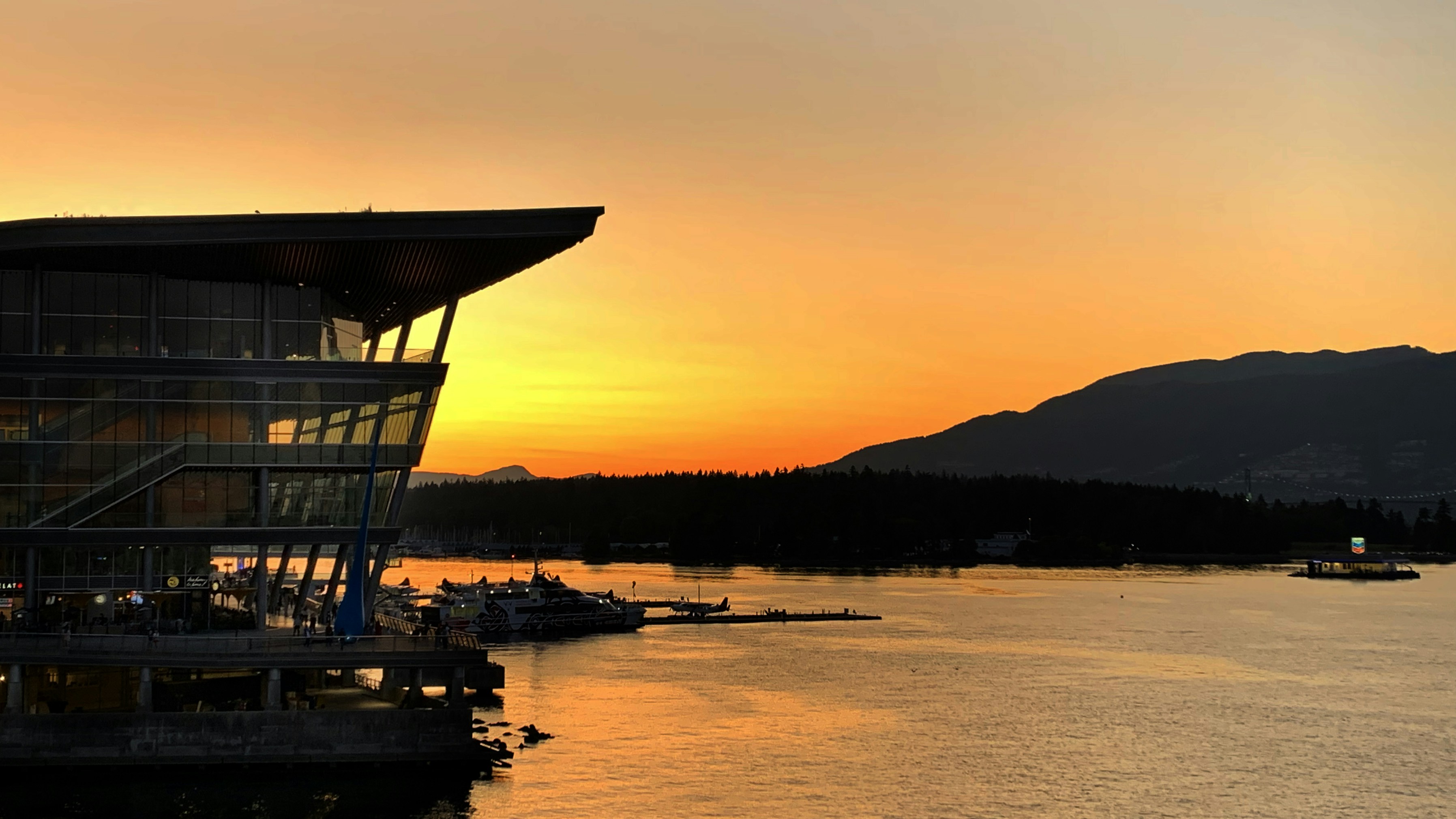 Una vista del atardecer de un muelle con barcos en el agua