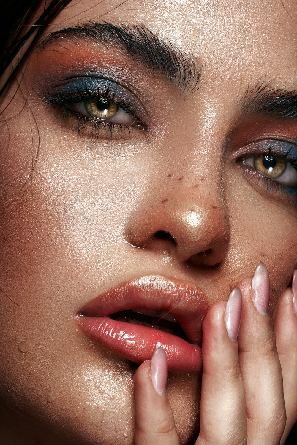 a close up of a woman's face with her hands on her face