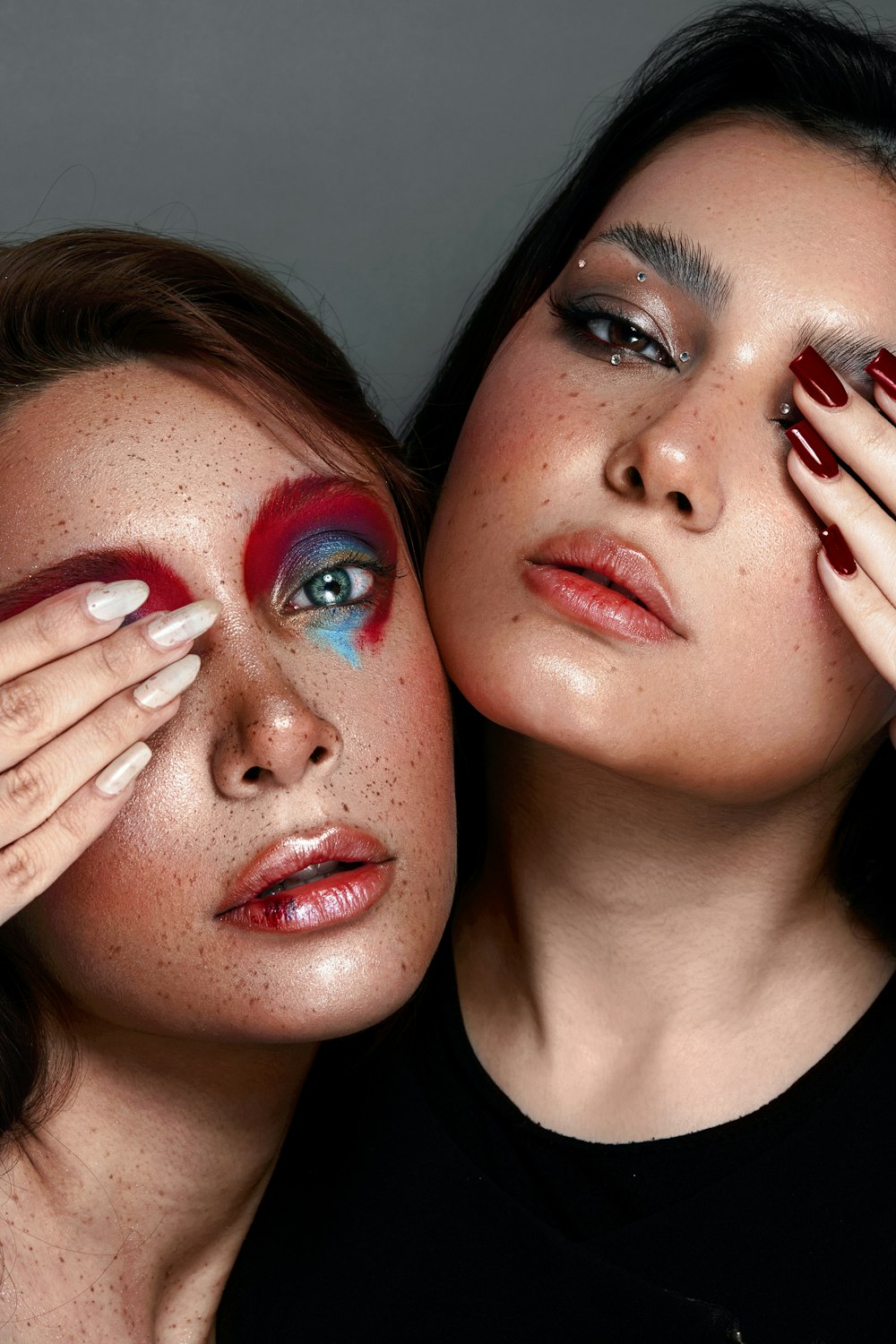 two women with red and blue makeup and nail polish