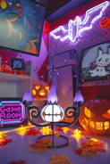 A dimly lit gallery room with glowing jack-o'-lanterns and punk-inspired Halloween art on the walls.