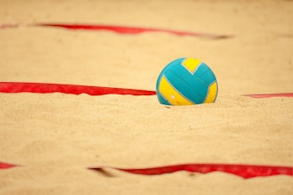 a volley ball sitting in the sand on a beach