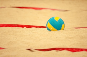 a volley ball sitting in the sand on a beach