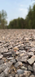 Close-up of a freshly laid gravel driveway with neat edging under soft sunlight.