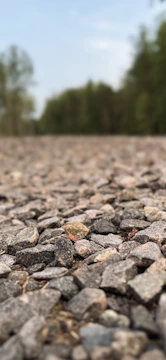 Close-up of a freshly laid gravel driveway with neat edging under soft sunlight.