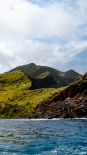 a grassy hill with a body of water in front of it