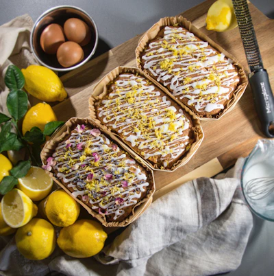 Close-up of freshly baked mini lemon loaves with a soft pink background.