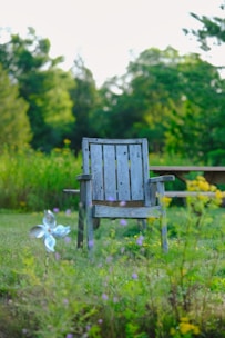 Close-up of a waterproof outdoor seat pad resting on a wooden chair beside a blooming garden.