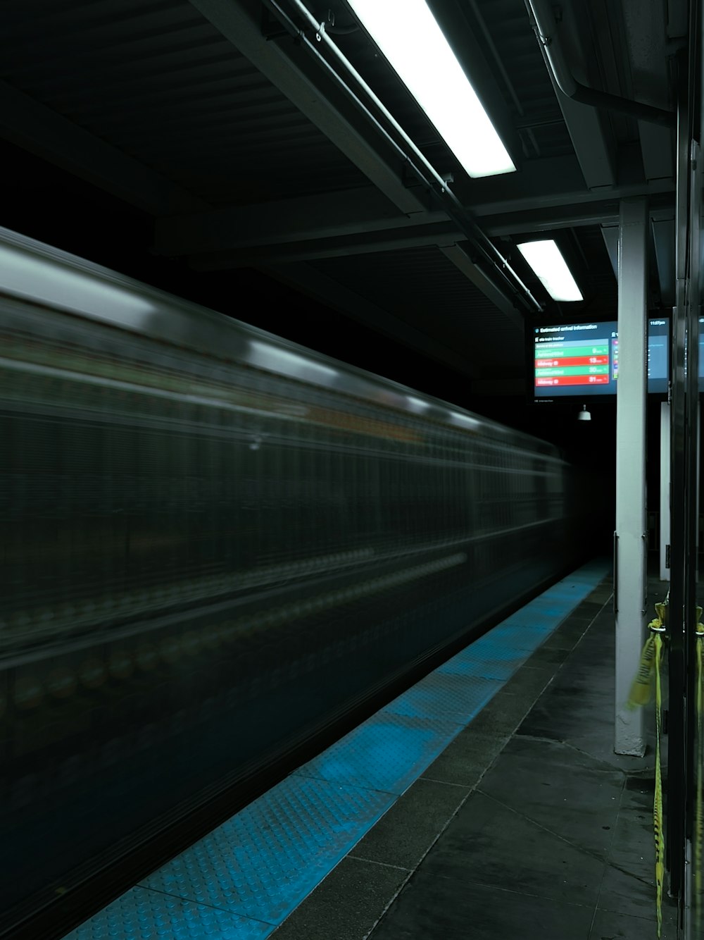 a train traveling through a train station next to a loading platform