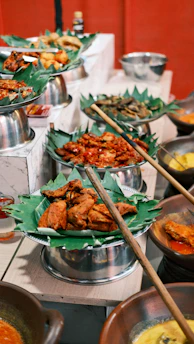 A colorful display of various gorengan and Indonesian specialties arranged on rustic wooden trays.