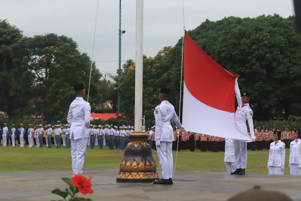 Paratroopers performing a ceremonial flag raising at a memorial site in Catalonia.
