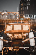 Elegant floating luxury boat docked on Igaratá lake with retro nautical design and wooden details at sunset.